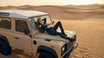 Chica tumbada sobre el capó de un Jeep