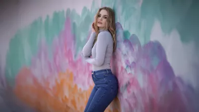 Rubia de pie junto a una pared