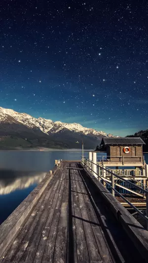 Estrellas en el cielo nocturno, lago y puente en nueva zelanda