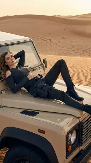 Chica tumbada sobre el capó de un Jeep