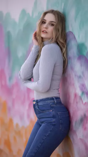 Rubia de pie junto a una pared