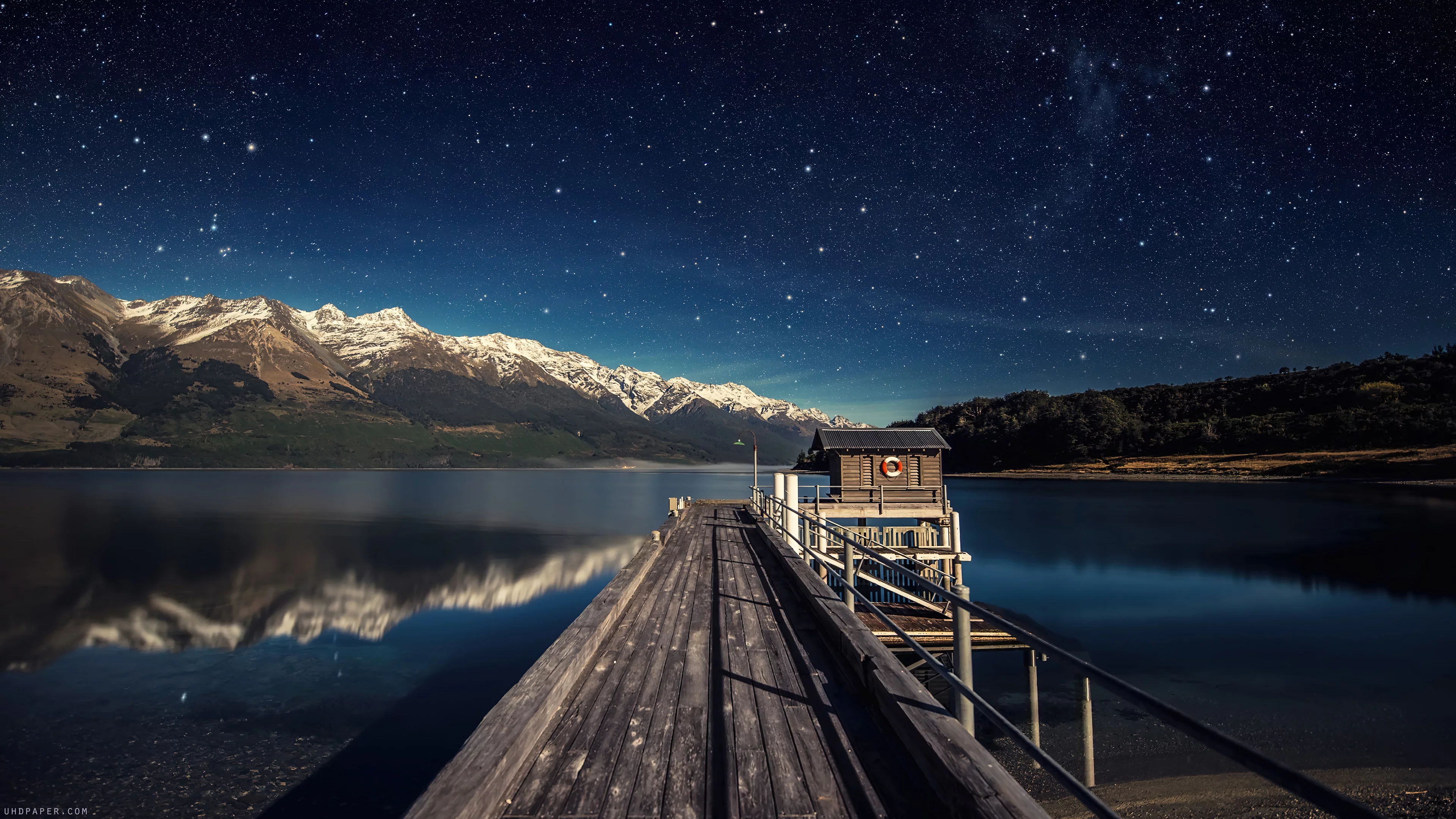 Estrellas en el cielo nocturno, lago y puente en nueva zelanda